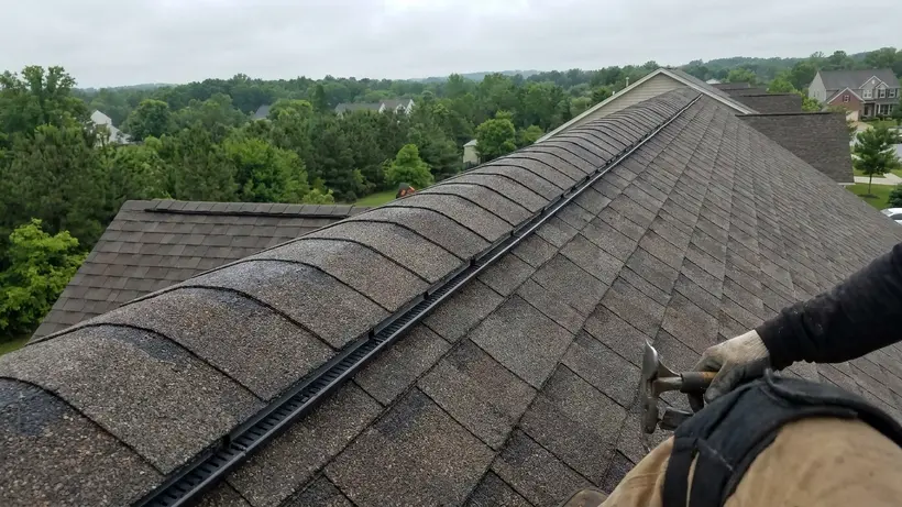 Continuous ridge vent installed on a residential asphalt shingle roof for proper ventilation.